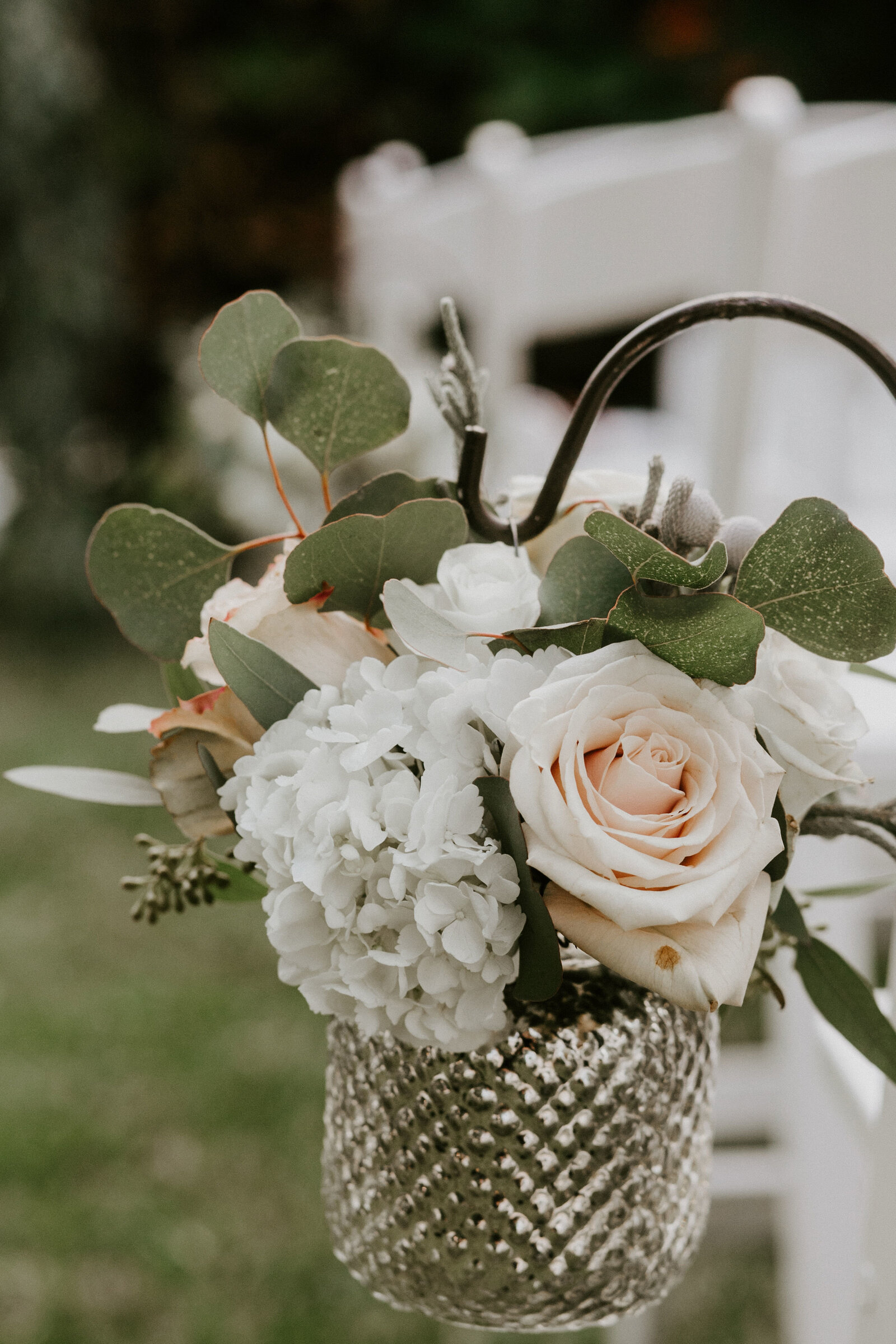 Open-air ceremony aisle lined with white chairs and a styled centerpiece