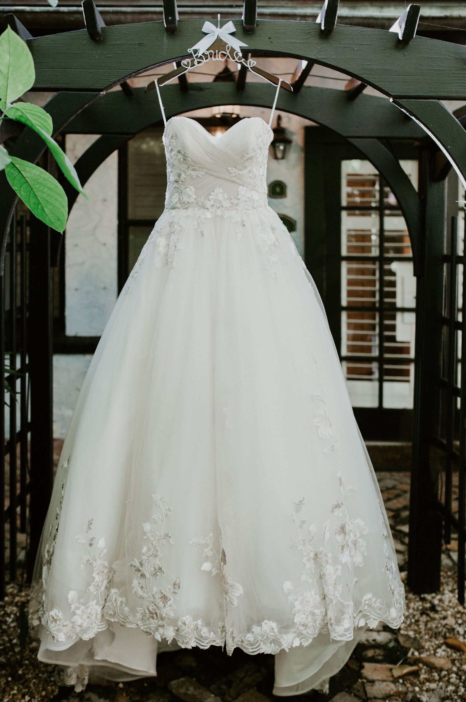 The wedding gown hanging in a garden gazebo before the ceremony