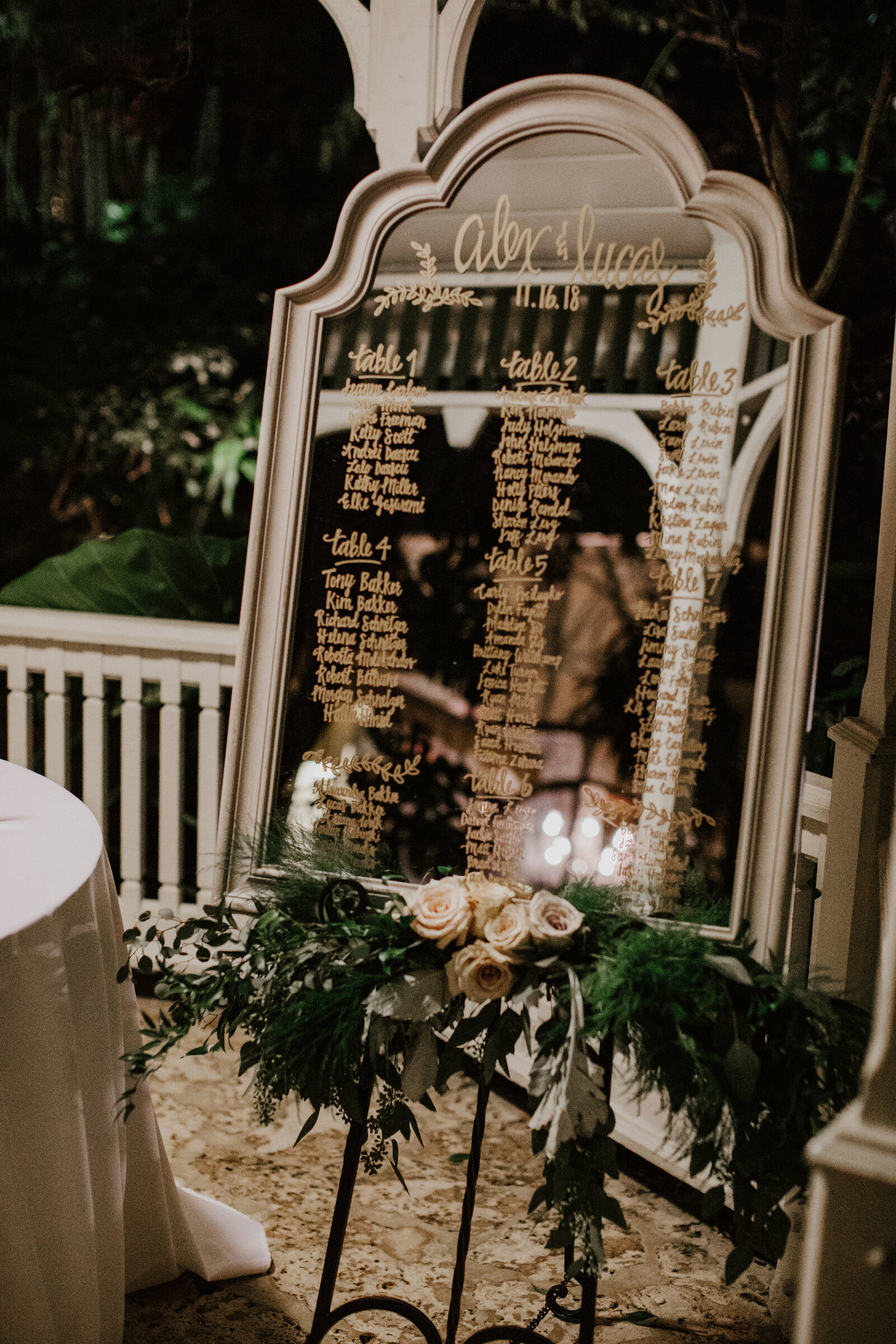 Elegant mirrored seating-chart display at the reception entrance